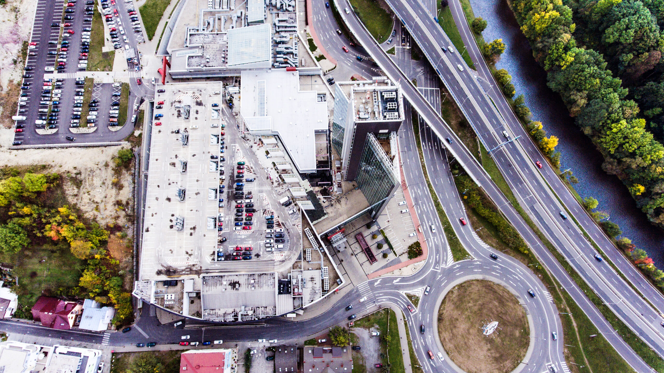 Aerial view, building, car park and highway passing through town.