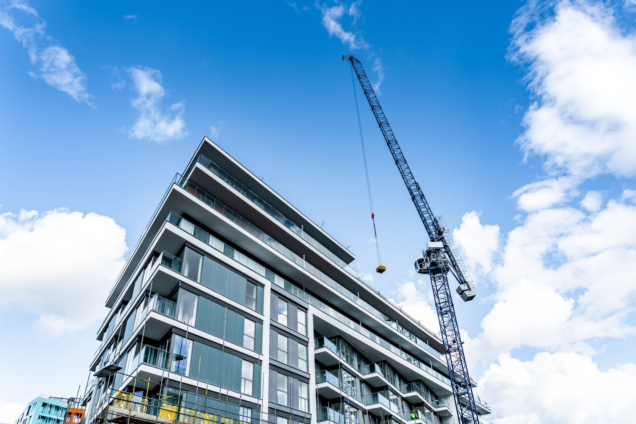 crane lifting construction equipment on building