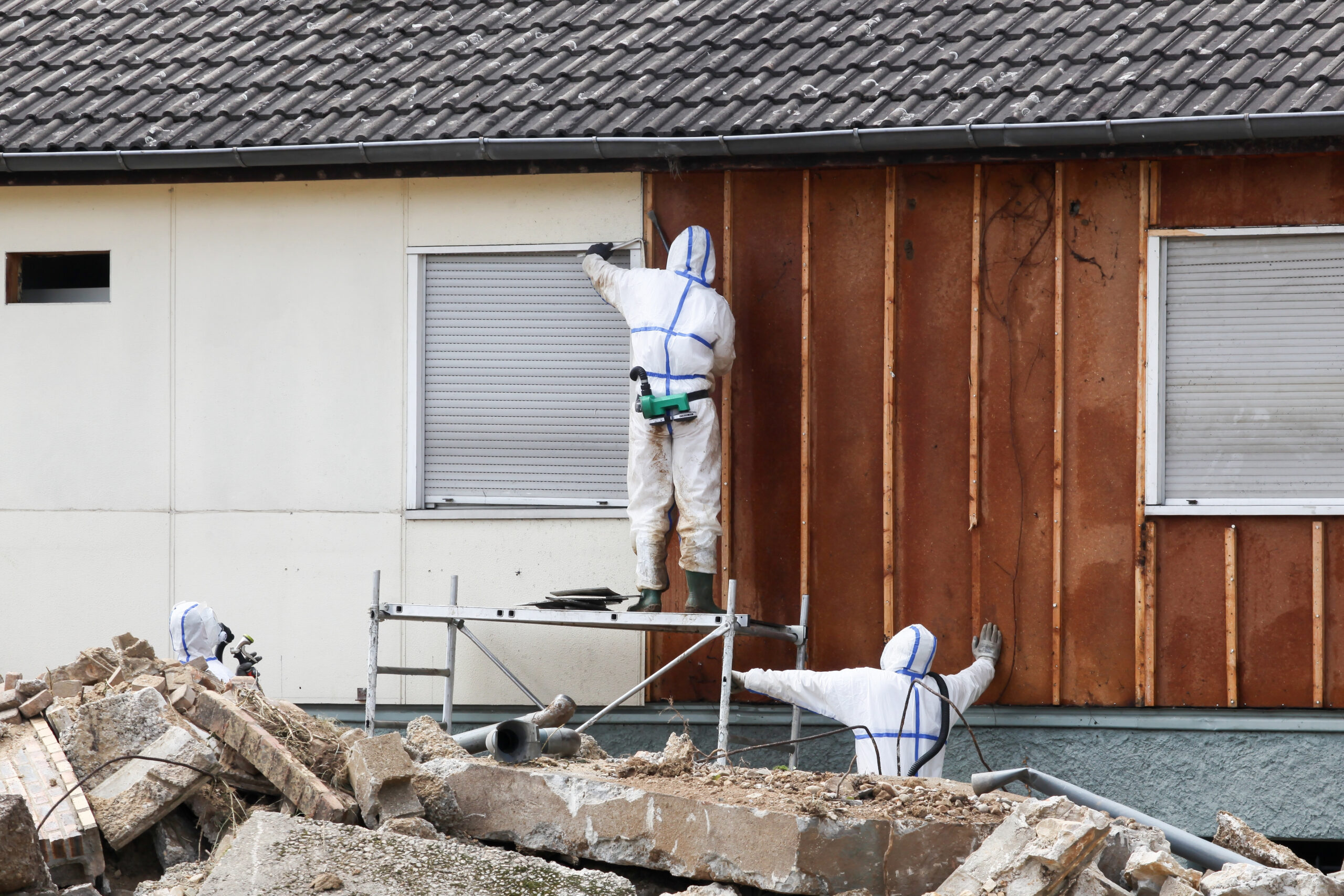 Professionals,In,Protective,Suits,Remove,Asbestos,On,A,Wall