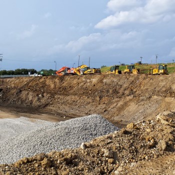 A deep, open ditch at an excavation site supported by trench boxes and shoring equipment, demonstrating Environmental Construction Support Services in excavation support and soil stabilization.