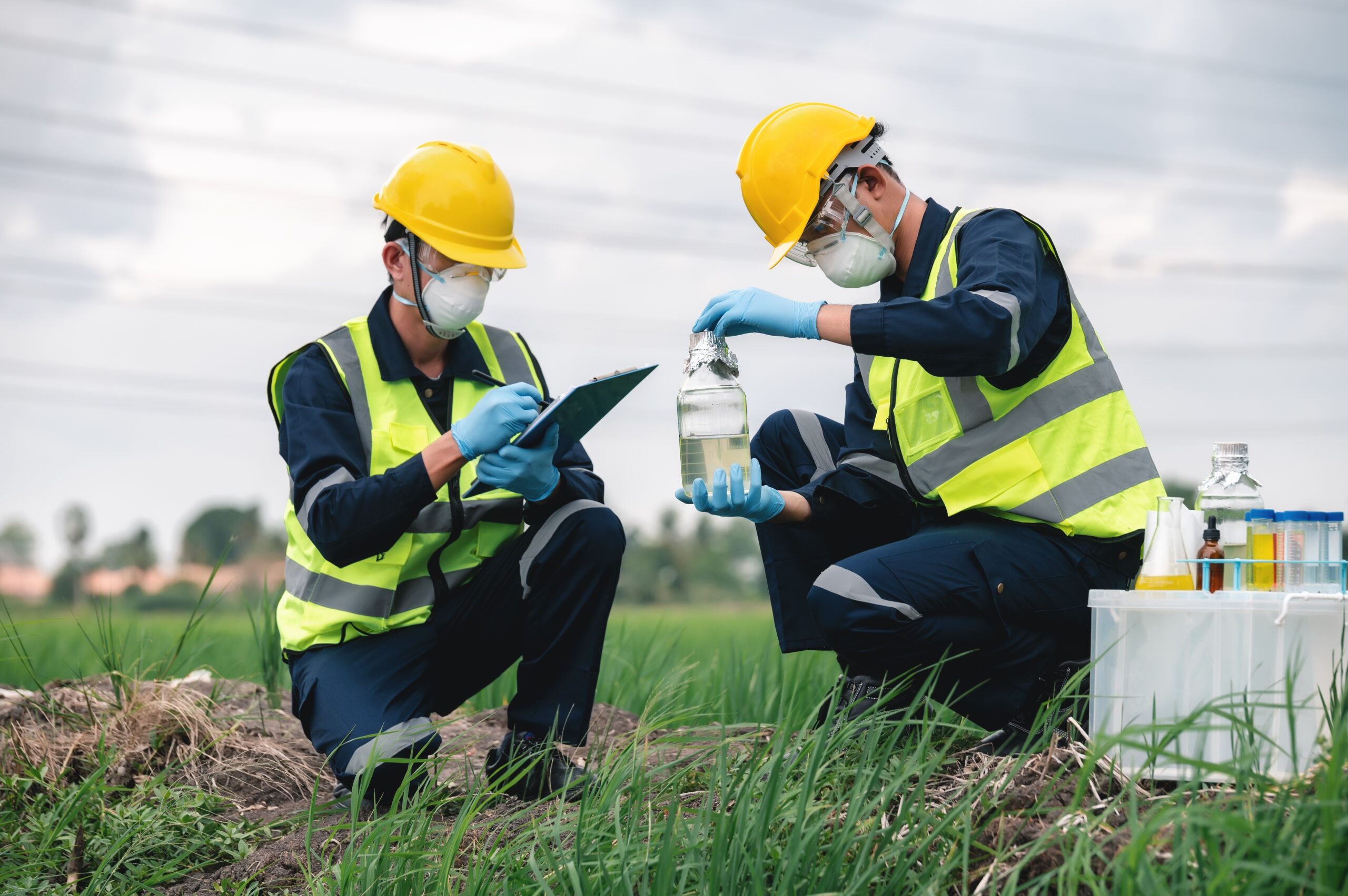 Two environmental engineers inspecting water quality and collecting water samples during a PFAS assessment as part of environmental due diligence.